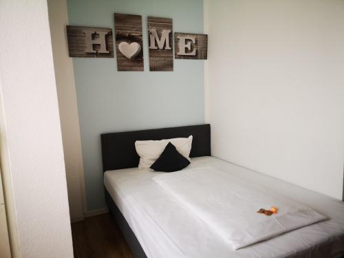 a bed in a room with two pictures on the wall at KEMPE Komfort Hotel in Düsseldorf