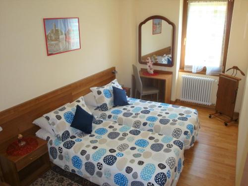 una camera da letto con un letto con un piumone blu e bianco di Casa Lucini a Campascio