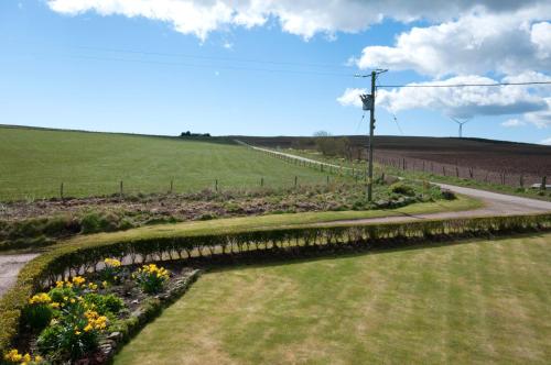 a garden with flowers in the middle of a field at Chapel of Barras B&B in Stonehaven