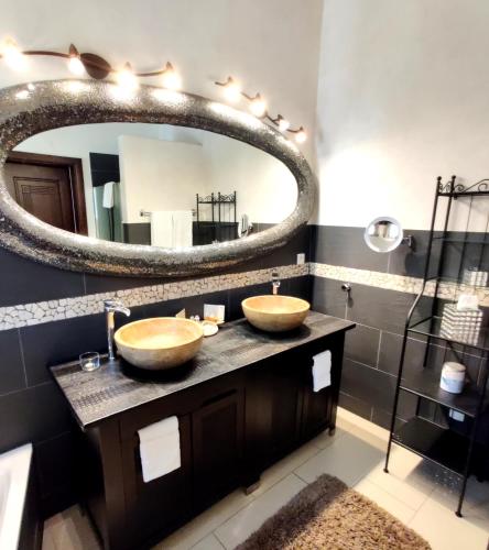 une salle de bain avec deux lavabos et un grand miroir dans l'établissement Maison Prestige Saint Tropez by Roberto Geissini, à Grimaud