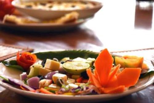 a plate of food with vegetables on a table at WelcomHeritage Shivavilas Palace, HAMPI in Hospet