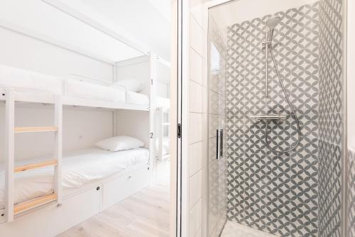 uma casa de banho com uma cabina de duche ao nível do chão ao lado de uma cama em Le Couvent - Hostel em Carcassonne