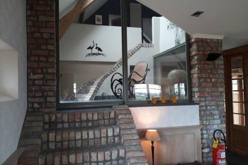a spiral staircase in a room with a window at Vakantiehoeve De Klepperij in Houthulst
