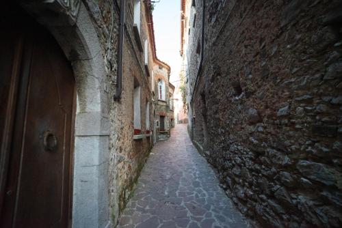 an alley with a stone wall and a door at Residenza Scaringelo in Caselle in Pittari