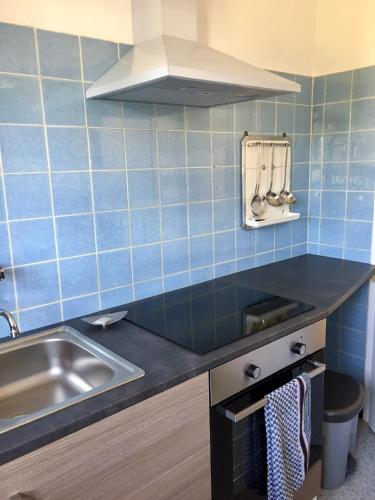 a kitchen with a sink and blue tiles at Blaues Haus in Niederdorfelden