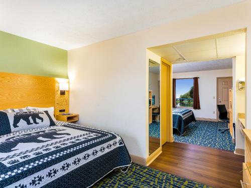 a hotel room with a bed and a mirror at Creekstone Inn in Pigeon Forge