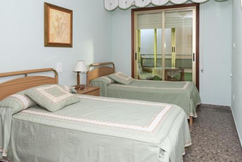 a room with two beds and a mirror at MARIVENT-A, 10-30 in Cullera