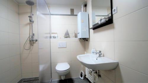 a bathroom with a sink and a toilet and a shower at Maye Oberhausen City Deluxe in Oberhausen