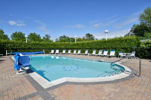 a pool of water with a blue umbrella at Bar Harbor Motel in Bar Harbor