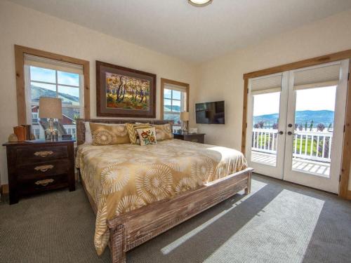 a bedroom with a large bed and a balcony at Rendezvous #20 in Chelan