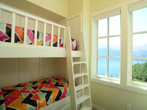 a bedroom with a bunk bed and two windows at Arroyo #60 in Chelan