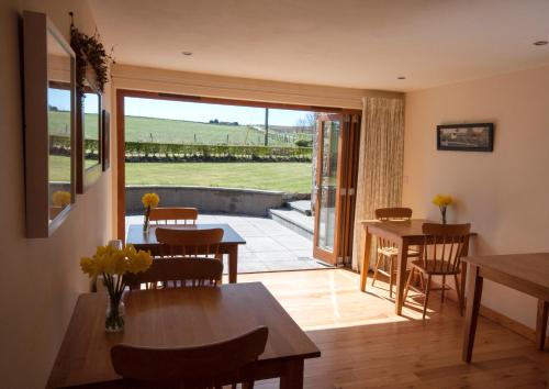 a dining room with a table and chairs and a patio at Chapel of Barras B&B in Stonehaven