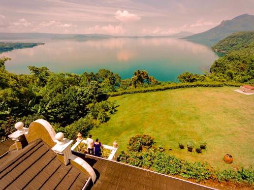 a group of people standing on a deck looking at a lake at Ataalaya Farmhouse in Batangas City