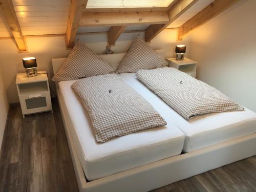 a bedroom with a white bed with two pillows at Penthaus Regine in Bruchhausen