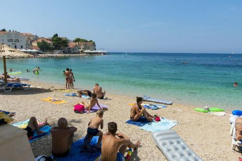 a group of people sitting on a beach at House Matilda in Primošten