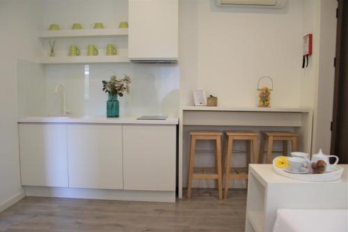 a kitchen with white cabinets and a sink at Casa Valxisto in Penafiel