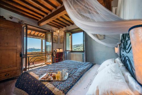 Un dormitorio con una cama con una bandeja de comida. en Villa Senaia, en Castiglion Fiorentino