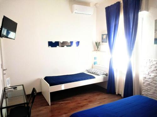 a bedroom with two beds and a blue curtain at B&B Ca' Nobil in Bernate Ticino