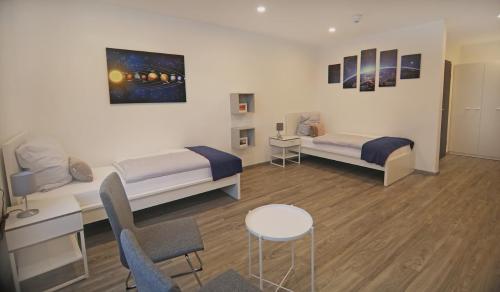 Cette chambre comprend deux lits, une table et des chaises. dans l'établissement CityPension-Vreden, à Vreden