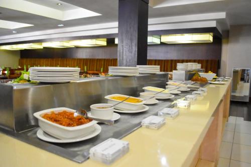 a buffet line with bowls and plates of food at Cresta Mahalapye Hotel in Mahalapye