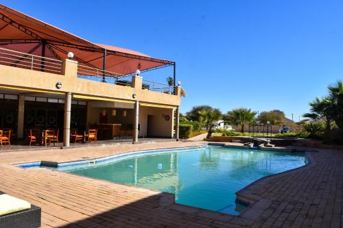 a swimming pool in front of a building at Cresta Mahalapye Hotel in Mahalapye