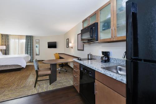 a hotel room with a kitchen and a bedroom at Candlewood Suites Louisville - NE Downtown Area by IHG in Louisville