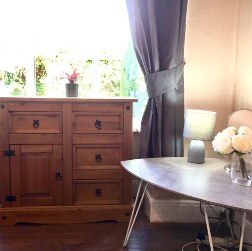 a room with a dresser and a table and a window at THE LIMES Guest House in Birmingham