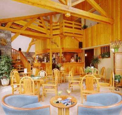 ヴァールにあるChalet-Hôtel Alpage & SPAの木製の椅子とテーブルのあるレストラン