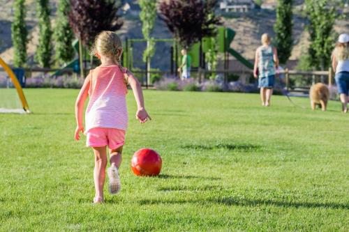 a little girl playing with a red ball in a field at Brass Monkey #74 in Chelan