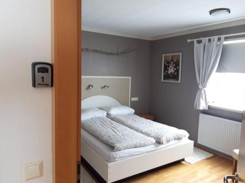 a bedroom with a bed and a mirror at Stóri-Bakki Guesthouse-with hot tub in Egilsstadir