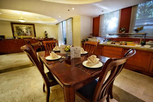 a dining room with a wooden table and chairs at Suites Obelisk in Mexico City