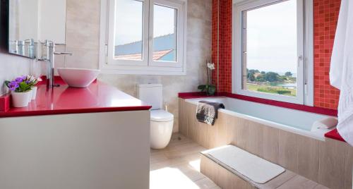 a bathroom with a red counter and a tub and a sink at CASA FEITIÑA: vistas al mar, moderna y funcional in Isla de Arosa