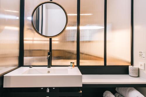 a bathroom with a white sink and a mirror at Getaway Studios Gent in Ghent
