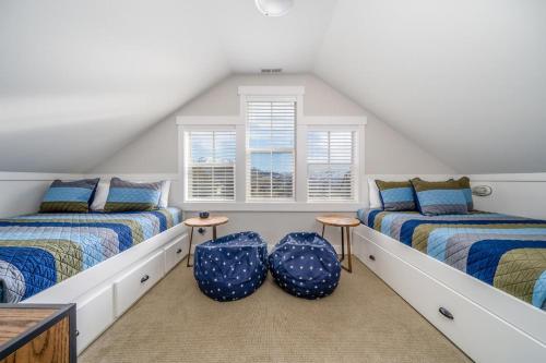 a attic room with two beds and two chairs at The Lakehouse #97 in Chelan