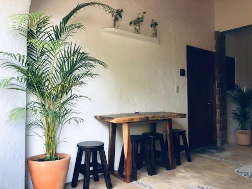 a table and stools in a room with a plant at Refugio del Cielo # in Sayulita