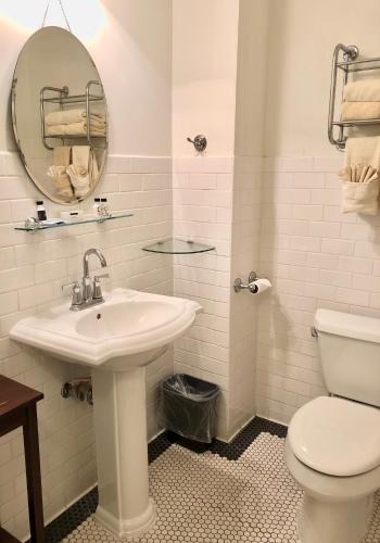 a white bathroom with a sink and a toilet at Hotel El Capitan in Van Horn