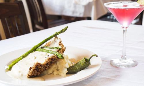 ein weißer Teller mit einem Stück Essen und einem Drink in der Unterkunft Hotel El Capitan in Van Horn