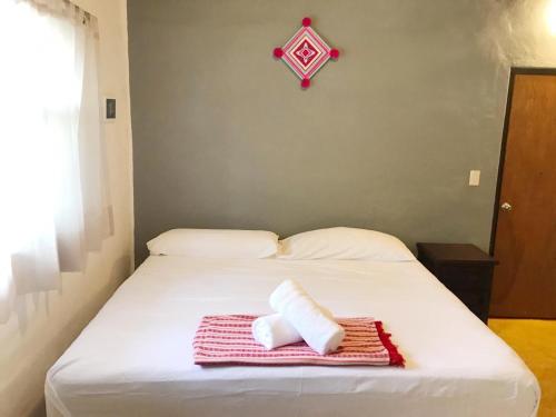 a white bed with two rolled towels on it at Refugio del Cielo # in Sayulita