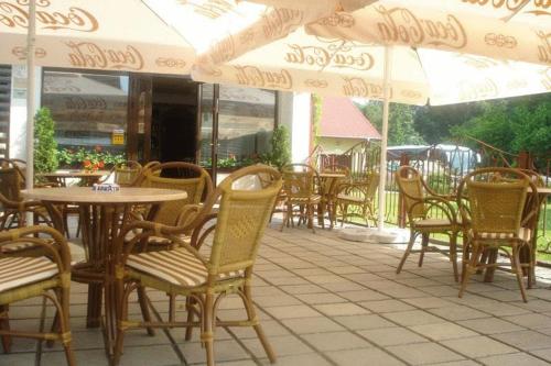 an outdoor patio with chairs and tables and umbrellas at Pension Hotel Fast in Rădăuţi