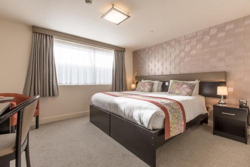 a bedroom with a large bed and a window at Mannin Hotel in Douglas