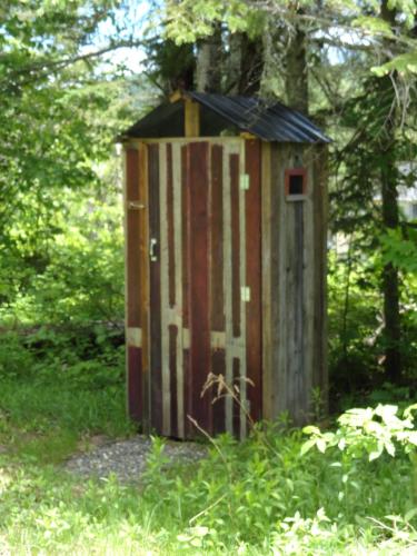 a wooden out house in the middle of the woods at Auberge Carpe Diem in Baie-Saint-Paul