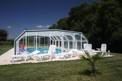 - un groupe de chaises blanches et une piscine dans l'établissement Résidence Romaric, à Jard-sur-Mer