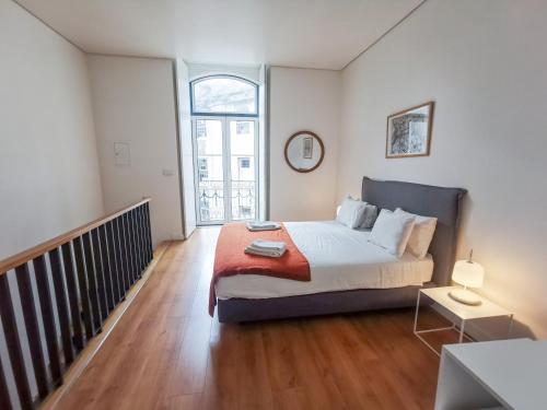 ein Schlafzimmer mit einem großen Bett und einer Treppe in der Unterkunft Fanqueiros Apartment in Lissabon