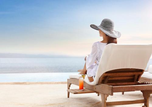 a woman sitting in a chair on the beach at Casa Velas Adults Only All Inclusive in Puerto Vallarta