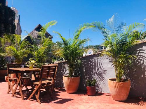 a patio with a table and chairs and palm trees at Refugio del Cielo # in Sayulita