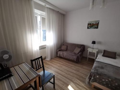 een kleine woonkamer met een bank en een tafel bij Studio Dymińska in Warschau