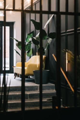 a living room with a yellow couch and a plant at Getaway Studios Gent in Ghent