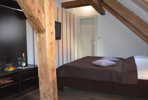 a bedroom with a bed and a television in it at Hotel Peregrin in Český Krumlov