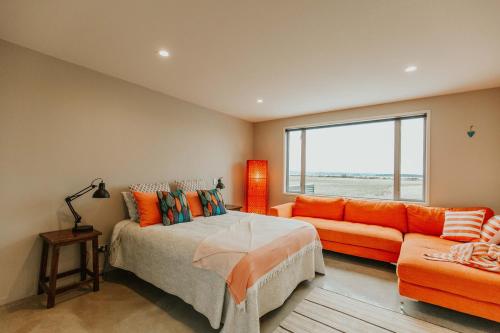 a bedroom with a bed and a couch and a window at Appleby House & Rabbit Island Huts in Mapua