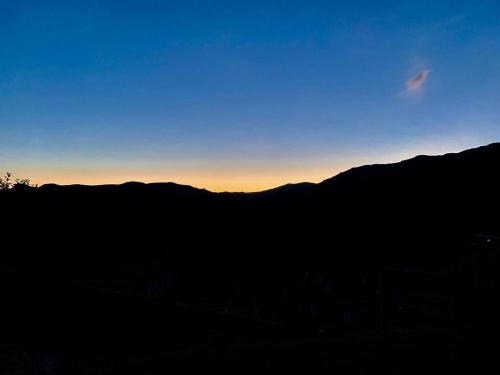 a silhouette of a mountain with the sunset in the background at Estâncias da Serra dos Alves in Itabira